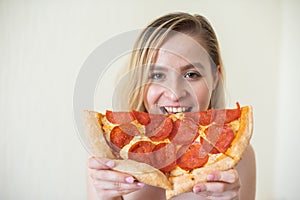 European girl with short hair posing with pieces of delicious pizza.