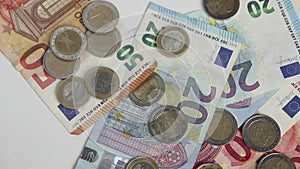 European greedy man catching euro money with euro bank notes and euro coins on white table with his hands for private pleasure