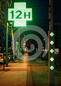 European green cross pharmacy store street sign 12h opened at night