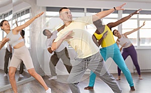 European guy with team of like-minded multinational people learn to elements of hip hop dance