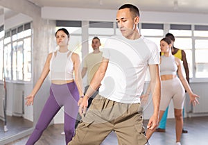 European guy with team of like-minded multinational people learn to elements of waacking dance
