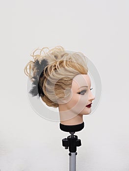 European hairstyle on the head of a mannequin on a light background