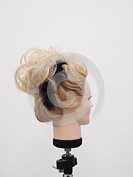 European hairstyle on the head of a mannequin on a light background