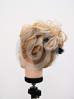 European hairstyle on the head of a mannequin on a light background