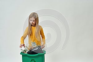 European little girl take garbage from dustbin