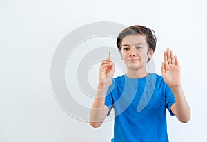 European-looking boy of8-9 years, wrote in the air on invisible whiteboard on a white background