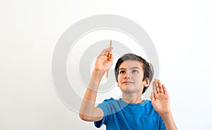 European-looking boy of8-9 years, wrote in the air on invisible whiteboard on a white background