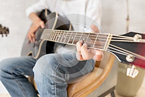 European male posing with acoustic guitar in his hands