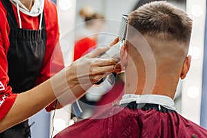 European man is cut by a barber. Men& x27;s haircutting with hair clipper