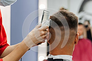 European man is cut by a barber. Men& x27;s haircutting with hair clipper