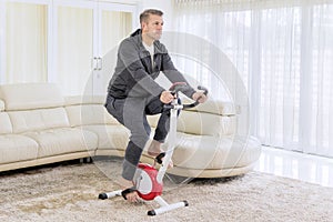 European man exercising on a spin bike at home