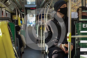 European man in a face mask traveling in public transport. Safety precautions