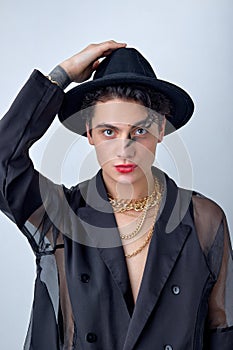 European man looking as woman in black shirt and hat posing at camera, isolated