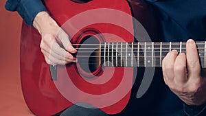 European man plays an red acoustic guitar photo