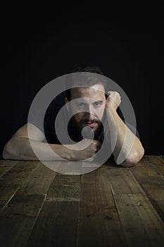 European man sitting at wooden table