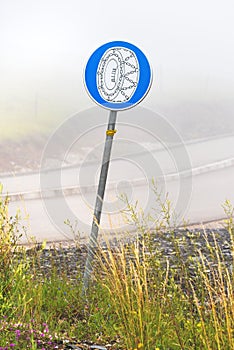 European mandatory snow chain wheels traffic sign in winter on cold foggy morning