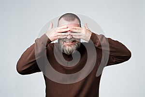 European mature man covering his face by hands