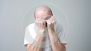 European mature man covering his face by t-shirt and peeping at camera