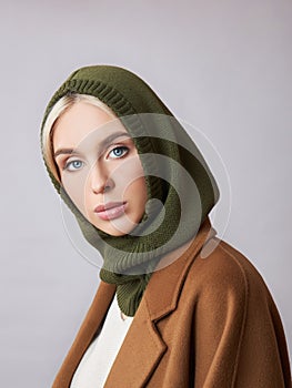 European Muslim woman with a blonde hair in a bonnet hood dressed on her head. Beautiful girl with soft skin, natural cosmetics