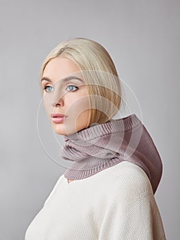 European Muslim woman with a blonde hair in a bonnet hood dressed on her head. Beautiful girl in sweater with soft skin, natural