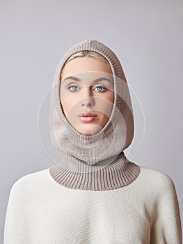 European Muslim woman with a blonde hair in a bonnet hood dressed on her head. Beautiful girl in sweater with soft skin, natural