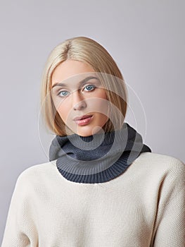 European Muslim woman with a blonde hair in a bonnet hood dressed on her head. Beautiful girl in sweater with soft skin, natural