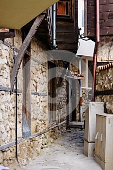 European narrow cobble-paved street between yellow classic houses in the old town. Bulgarian traditional small passage between