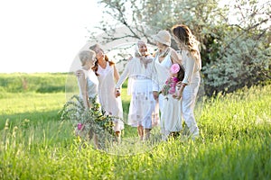 European old granny standing with daughters, granddaughters and grand granddaughter outside.