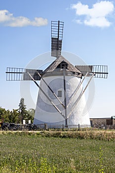 European old windmill, rural landscape, tiled roof, blue sky.