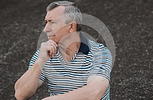 European senior man with sad mood, outdoor portrait of retired man