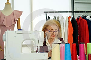 The european senior woman fashion designer working with fabric