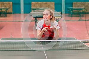 European smiling woman holding a ball and a racket in the gym photo