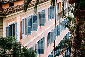 European style windows with wooden shutters. Building exterior.