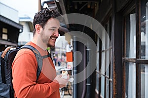 European tourist eating a nikuman standing at a japanese street in Takayama.