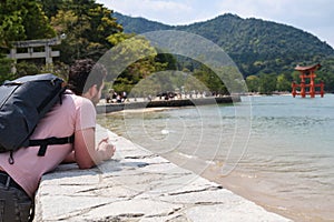 European tourist visit Itsukushima Jinja Otorii on the sea of Miyajima, Japan.