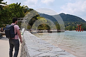 European tourist visit Itsukushima Jinja Otorii on the sea of Miyajima, Japan. photo