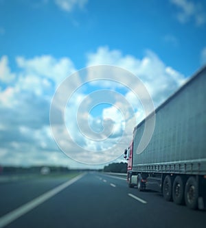 European truck vehicle on motorway with blue sky and white clouds. Cargo transportation.