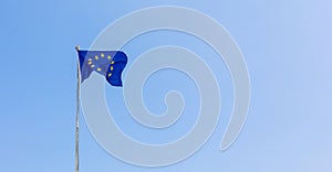 European Union EU flag is flying on blue sky background. Banner, place for text