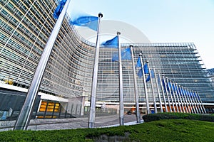 European Union EU flags waving in front of the Berlaymont building, headquarters of the European Commission in Brussels.