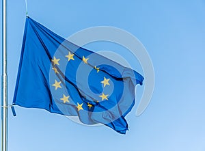 European Union flag flying in front of bright blue sky.