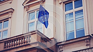 European Union flag waving on building in Brussels, Belgium, symbol of EU Parliament, Commission and Council
