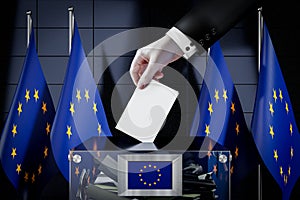 European Union flags, hand dropping ballot card into a box - voting, election concept