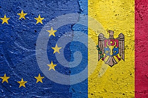 European Union and Moldova - Cracked concrete wall painted with a EU flag on the left and a Moldovan flag on the right stock photo