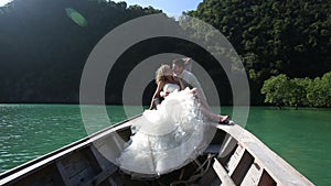 european wedding couple sitting in longtail boat