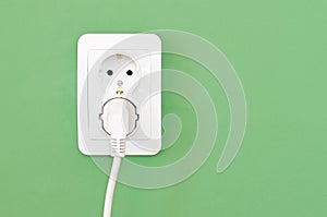 European white electrical outlet socket and white cable pluged i