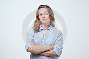 European woman in blue shirt with serious facial expression.