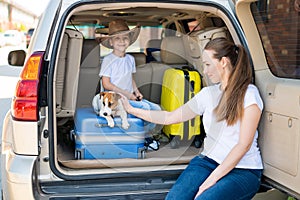 European woman with son and puppy Jack Russell travel by car. kid and his mother and a small dog are sitting in the