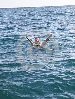 Žena pobyt na vode korok záchrannej vesta v otvoriť oceán a ukazuje palec hore 