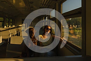 a European woman in sunglasses and a Labrador retriever dog in an empty train car are driving and looking out the window