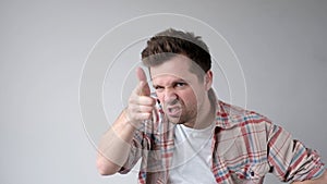 European young man menacingly stares into the camera and points his index finger, saying you are next. s photo